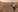 A space rover with many robotic elements is on a reddish rocky terrain. 