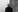 Professor Martin Paul Eve in black and white facing the camera and leaning against a wall 